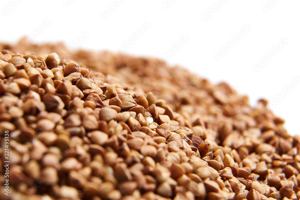 Obraz premium Heap of Buckwheat grains. Dry brown kernel on white background. Selective focus
