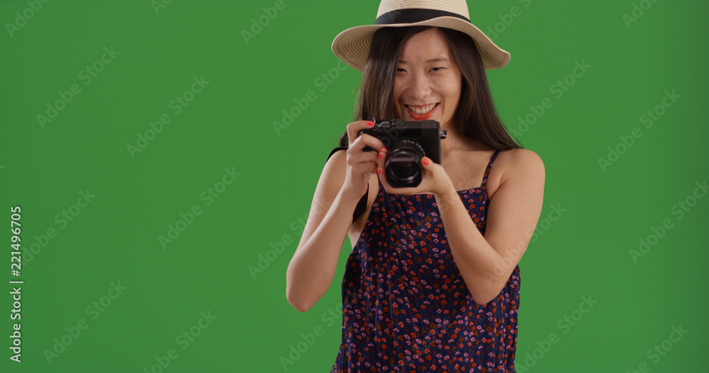 Happy Asian tourist woman with camera and taking pictures on green screen Happy Asian tourist woman with camera and taking pictures on green screen