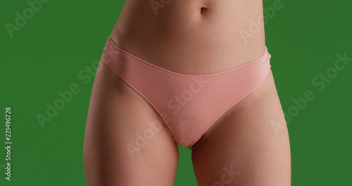 Close up portrait of young woman's hips and thighs on green screen