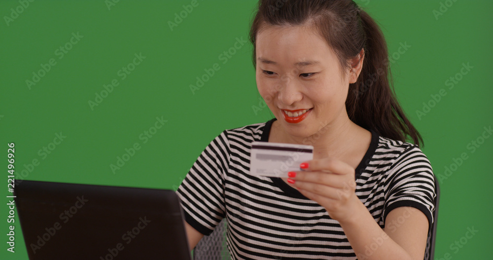 Portrait of Asian woman shopping online with laptop on green screen Portrait of Asian woman shopping online with laptop on green screen