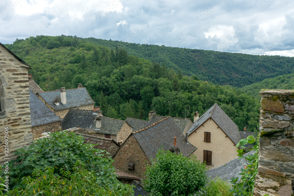 View of slate roofs old house in a french village. Green mountain in the background