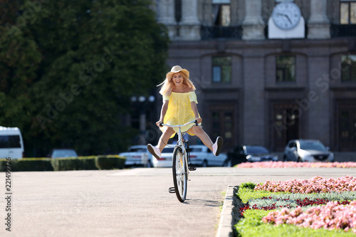 Beautiful happy woman riding bicycle on street