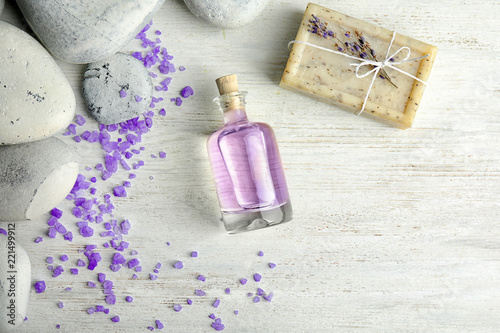 Fototapeta Naklejka Na Ścianę i Meble -  Flat lay composition with natural herbal oil, soap and lavender flowers on wooden background. Space for text