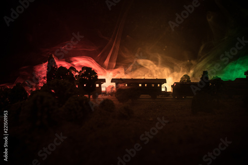 Train moving in fog. Ancient steam locomotive in night. Night train moving on railroad. toned foggy fire background. Horror mystical scene.