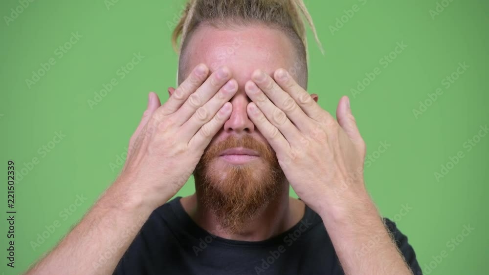 Handsome bearded man with dreadlocks covering eyes as three wise monkeys concept