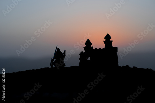 Medieval battle scene on sunset. Silhouettes of fighting warriors on sunset background. © zef art
