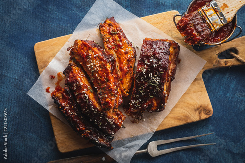 Smoked Roasted pork ribs over blue background. Barbeque spicy ribs. Traditional american BBQ food