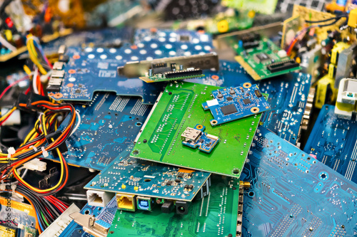 E-waste heap from discarded laptop parts. Connectors, PCB, notebook cards. Colorful blurry background from PC components. Idea of electronics industry, eco, sorting and disposal of electronic waste. photo