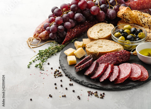 Salami sliced in rustic style. Salami sausage. Different sausages with cheese, grapes and olive