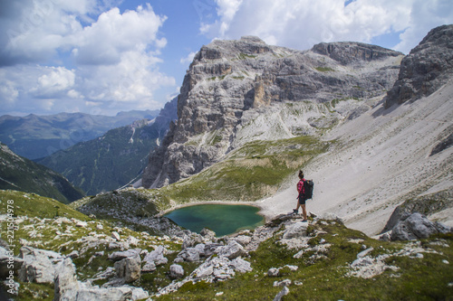 Young active hiker tourist man walking/hiking Tre Cime di Lavaredo trail in Dolomites, Italy, Europe. Beautiful mountain scenic landscape view. Summer outdoor activity or active holiday concept.