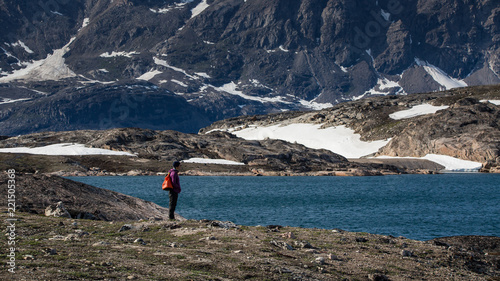 Greenland, Scoresby Sund arctic landscape with rough mountains  and a tourist hiking photo