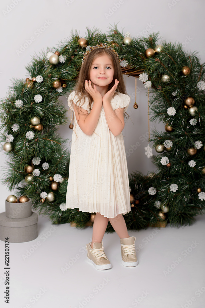 Christmas celebration. Cute little girl in a beautiful dress on Christmas. Merry Christmas and Happy New Year. Cute girl with christmas presents