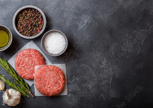 Raw minced home made grill beef burgers with spices and herbs. Top view with space for your text