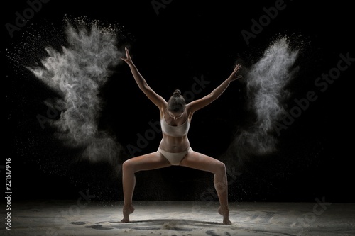 Young girl dancing in a burst of white powder