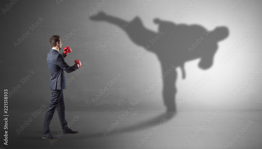 Businessman fighting with his strong karate man shadow
Businessman fighting with his strong karate man shadow