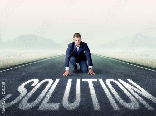 Young determined businessman kneeling before solution text