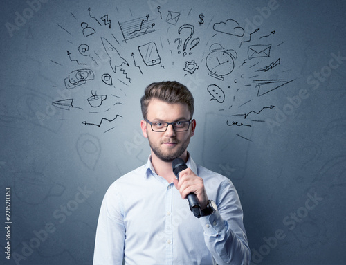 Businessman speaking into microphone with mixed doodles over his head