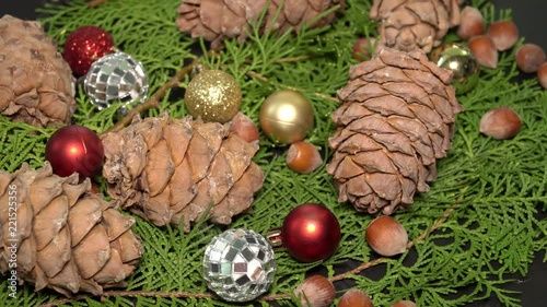 Pinecones and Baubles Rotationg on Fir Tree Branches. Cristmas Background photo