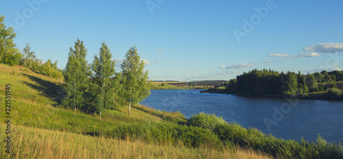 Sunny summer landscape with river,fields,green hills and beautiful clouds in blue sky.River Krasivaya in Tula region,Russia. 