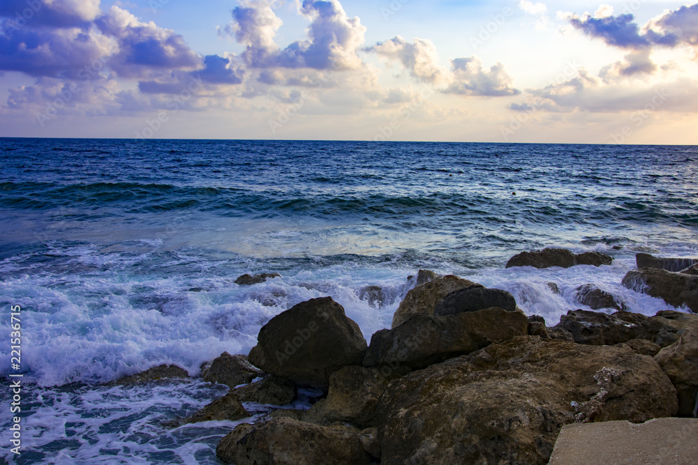 Obraz premium Landscape of the sundown in sea water amongst rocky beach