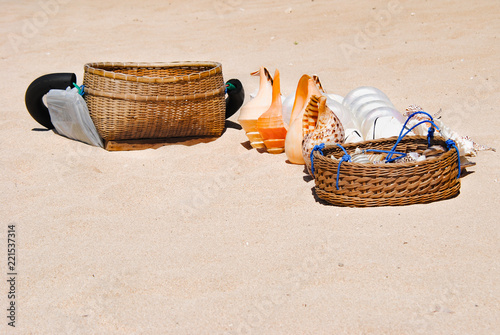 Large sea shells and wicker baskets in the sand on the beach of Nusa Duo.The Island Of Bali 