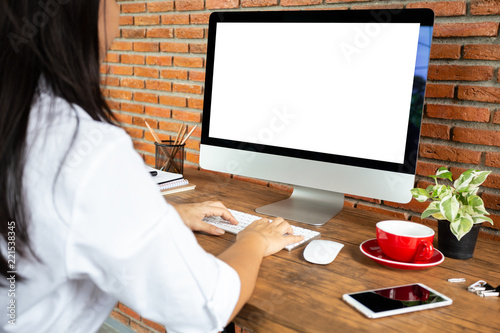 young woman working empty screen computer on wood desk in home office. with clipping path