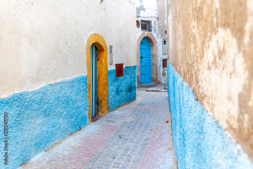 In an alley of Essaouira in Morocco. The blue and white walls of a house are pierced by a door framed by yellow © Louis-Michel DESERT