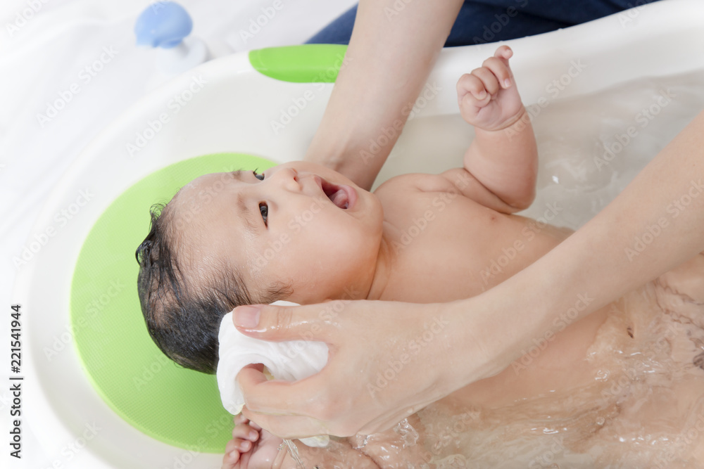 新生児の入浴 沐浴方法を説明するマニュアル用写真 耳の洗い方 拭き方 Stock Photo Adobe Stock
