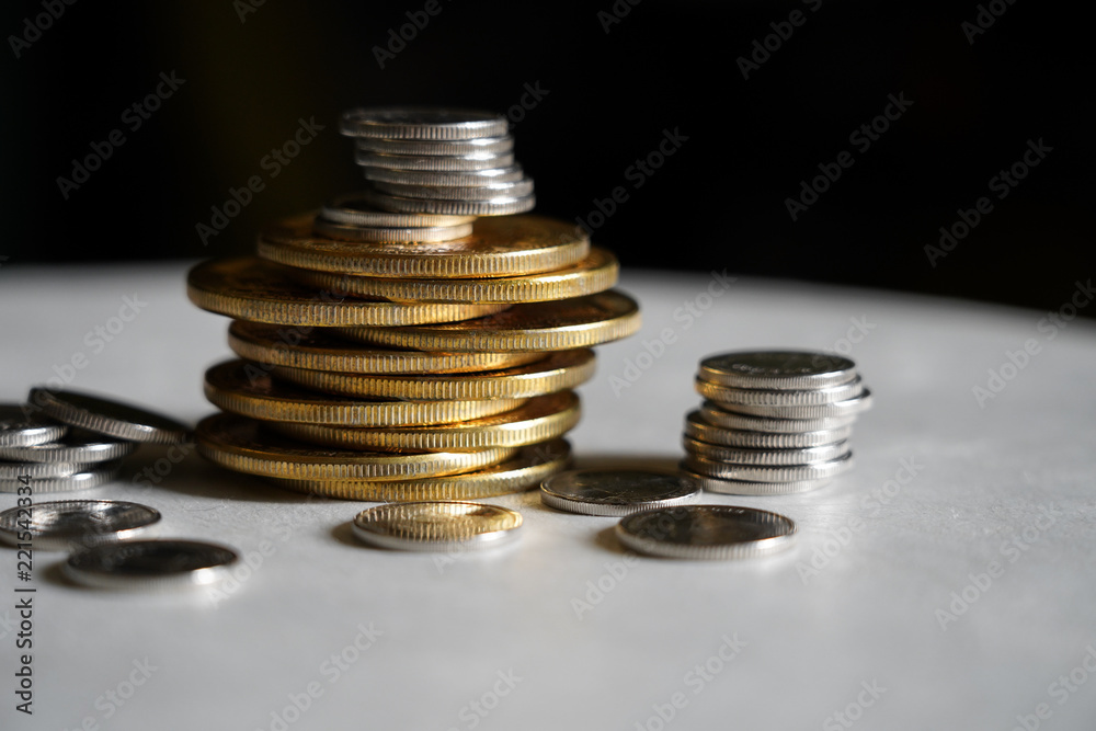 Macro shot detail of golden and silver color coin stacks on dark background with copy space for text. Business and finance growth, saving money, investment and interest concept. Macro shot detail of golden and silver color coin stacks on dark background with copy space for text. Business and finance growth, saving money, investment and interest concept.