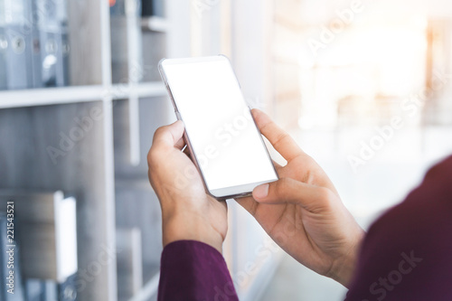 Mockup image of man's hands holding white mobile phone with blank screen technology and lifestyle concept.