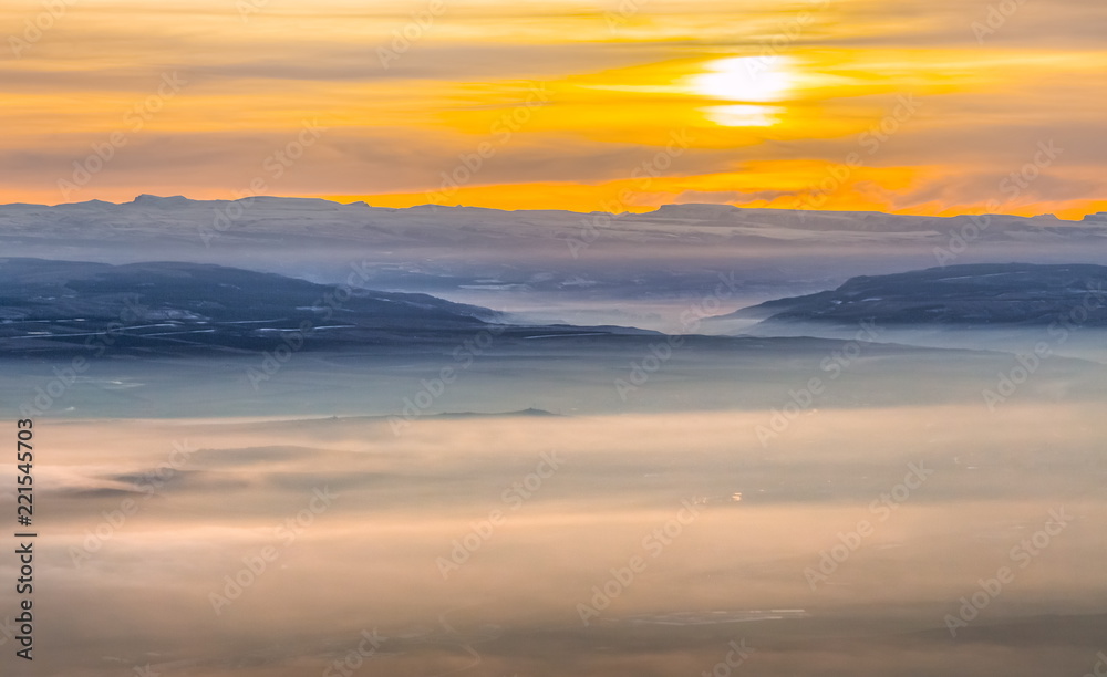 Mountains in the fog, haze. The Main Caucasian Range. Multicolored background. Mountains at sunset. Winter fog.