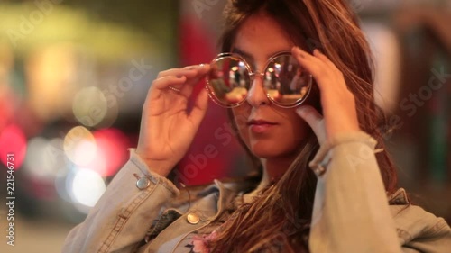 Girl checking herself in front of mirror with big round sunglasses at night2 photo