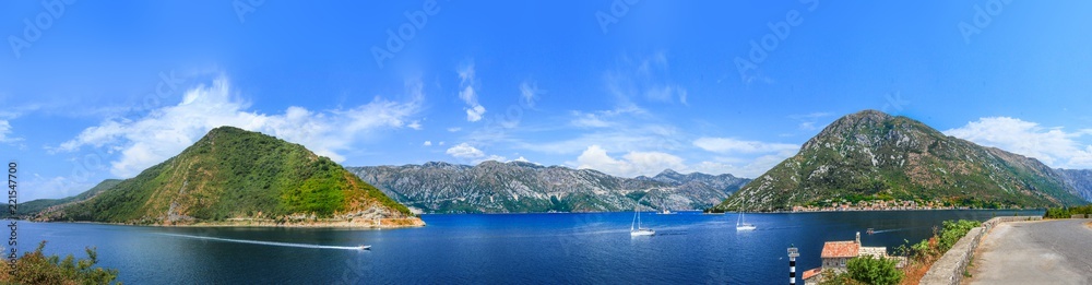 A panorama of the black mountains surrounding the bright blue gulf of the bay, cutting white yachts.