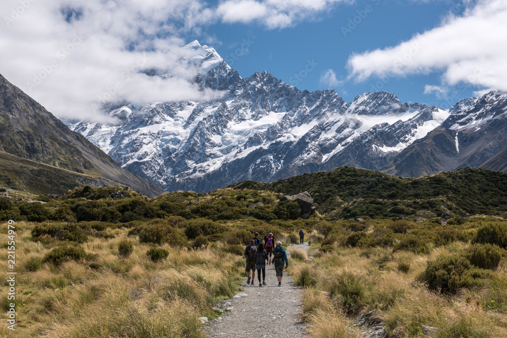 Hikers on the Hooker Valley track with Mount Cook in the background. In Aoraki/Mount Cook National Park, New Zealand. Hikers on the Hooker Valley track with Mount Cook in the background. In Aoraki/Mount Cook National Park, New Zealand.