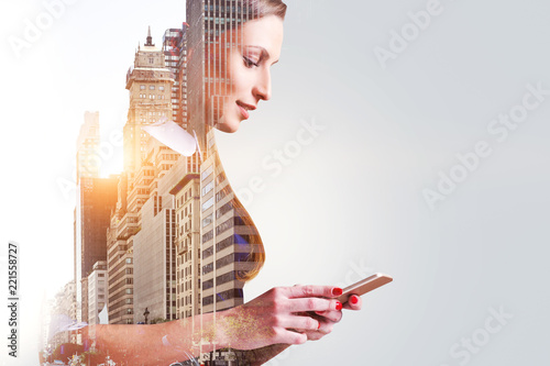 Smiling woman with smartphone in city, copy space photo