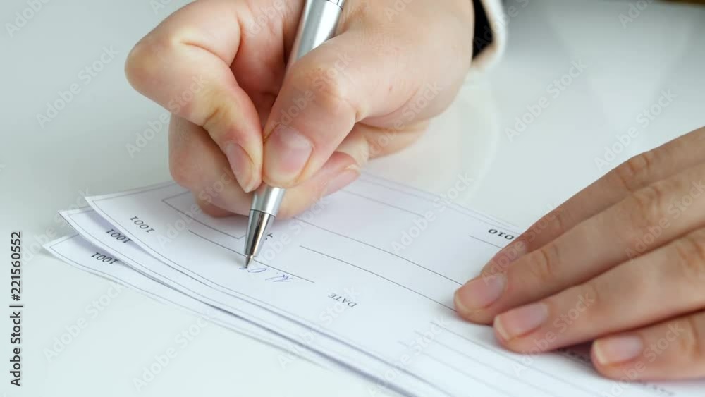 Closeup 4k video of young woman filling empty bank cheque Closeup 4k video of young woman filling empty bank cheque