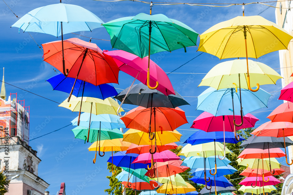 Different colorful umbrellas hanging over the street against sky Different colorful umbrellas hanging over the street against sky