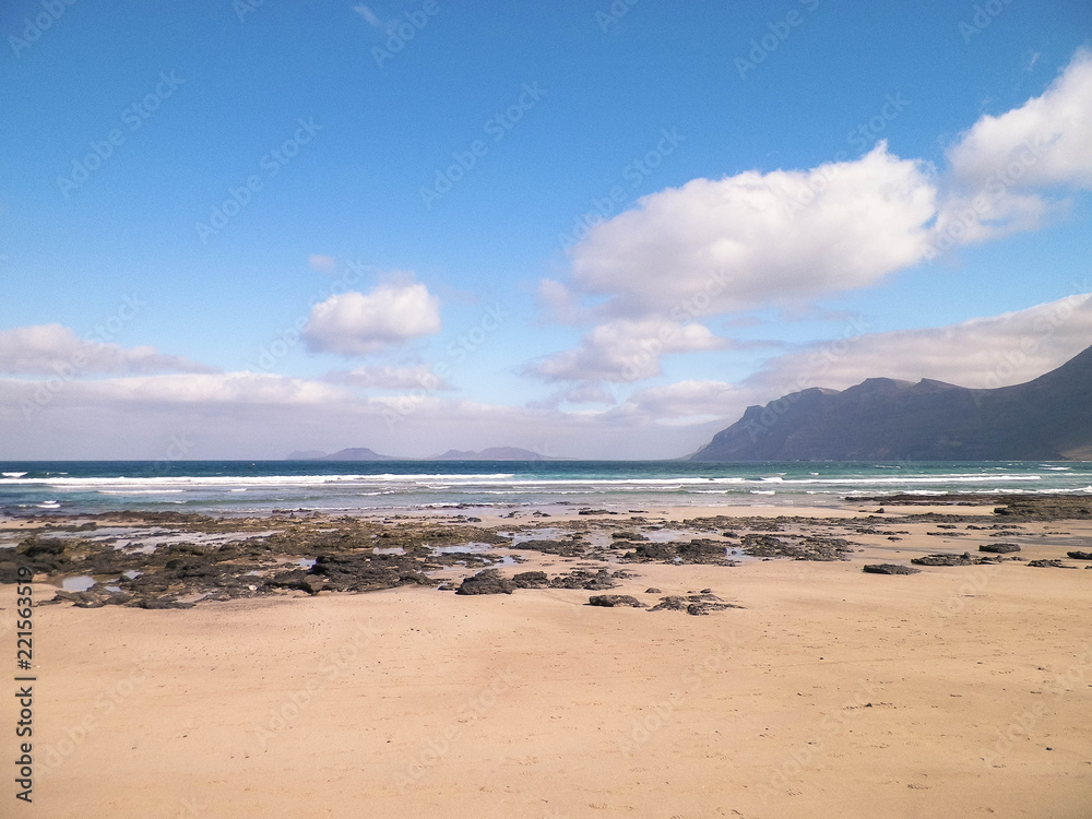 Beach and mountains - beautiful coast in Caleta de Famara, Lanzarote Canary Islands. Beach and mountains - beautiful coast in Caleta de Famara, Lanzarote Canary Islands.