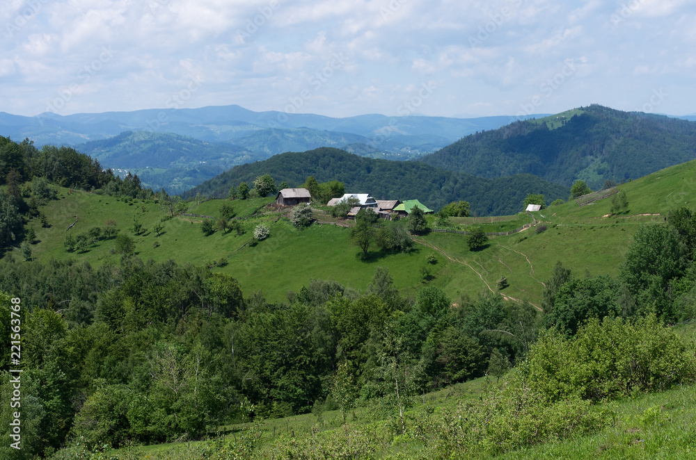 A small village in the background of a beautiful mountain landscape in Carpathian; Typical Ukrainian scenery