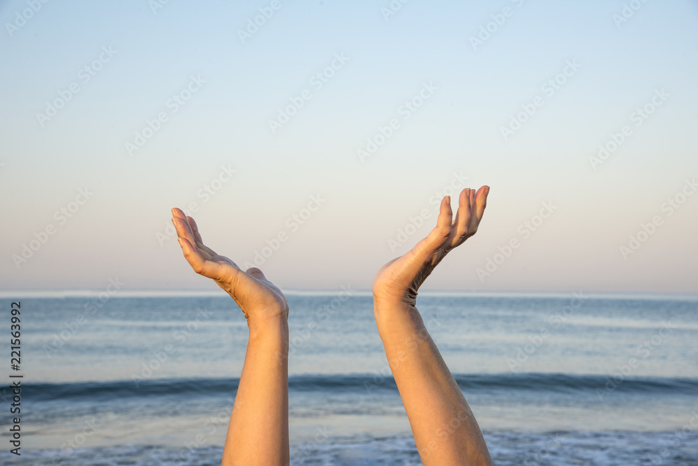 Hands up in the air by the sea. The hope and spiritual concept
