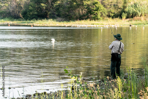Canvas-taulu Back turned fisherman fishing in a lake