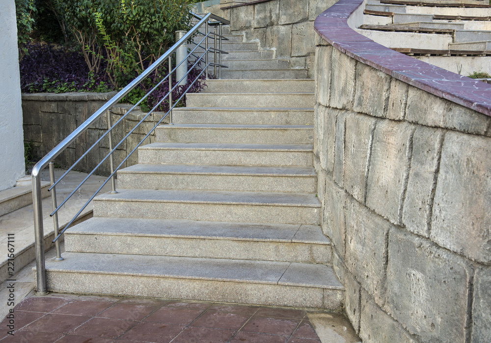 Outdoor stone staircase. Stone steps of old staircase with stainless steel