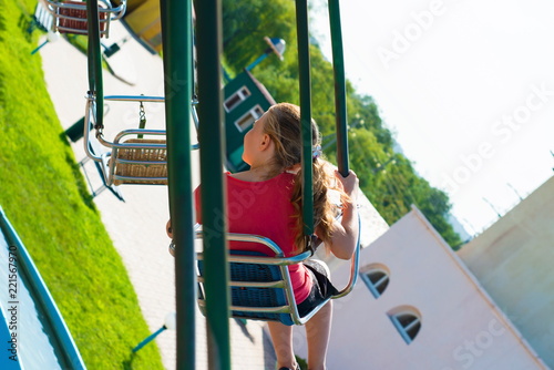 The girl is riding a carousel at high speed on a swing. photo