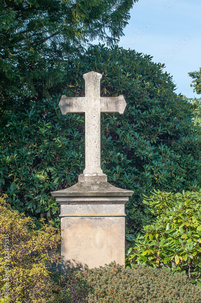 Kreuz-Grabmal auf dem Friedhof von Herdecke vor grünen Hecken aus Rhododendren Kreuz-Grabmal auf dem Friedhof von Herdecke vor grünen Hecken aus Rhododendren