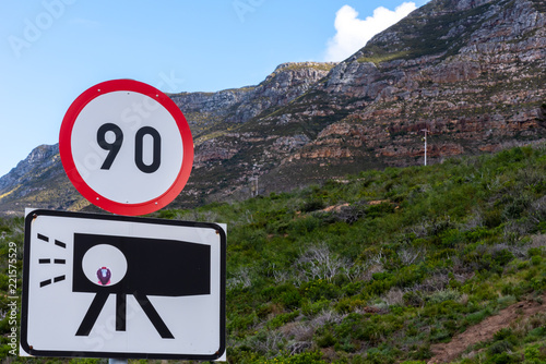 Speed and camera trap road sign with mountain background.
