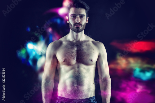 Handsome young muscular man shirtless, on black background in studio shot