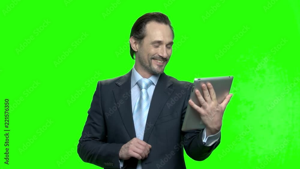 Successful businessman with tablet talking. Man talking on tablet computer having video chat with his kids and wife. Green hromakey background for keying. Successful businessman with tablet talking. Man talking on tablet computer having video chat with his kids and wife. Green hromakey background for keying.