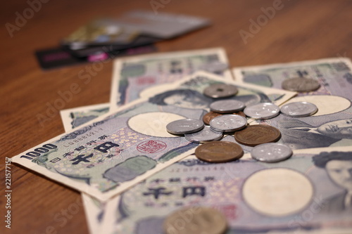 テーブルの上にばらまかれた日本のお金とクレジットカード