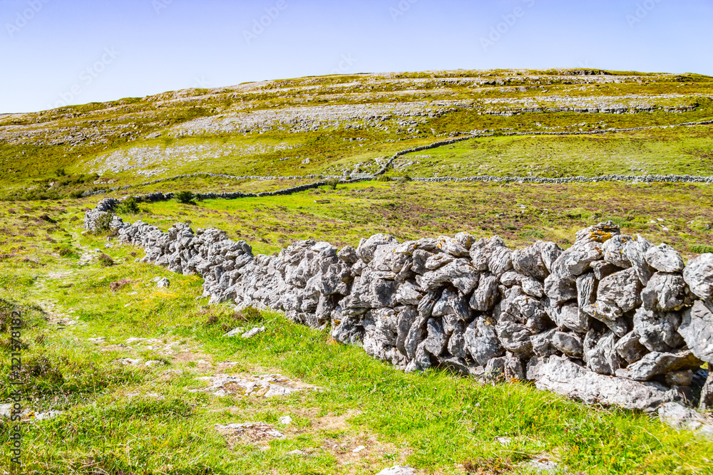 Farm fields with stone wall in Burren way trail