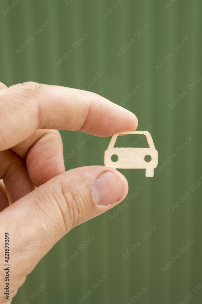The hand keeps the car on a blurry green background. Car insurance. Man is holding car. my car. vertical photo The hand keeps the car on a blurry green background. Car insurance. Man is holding car. my car. vertical photo